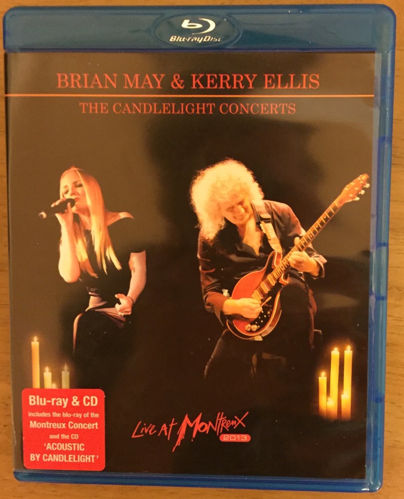 Blu-Ray cover for Kerry Ellis & Brian May's Candlelight Concert, showing Kerry singing and Brian on guitar, with candles behind them. Set includes Montreux Concert Blu-Ray and Acoustic By Candlelight CD.