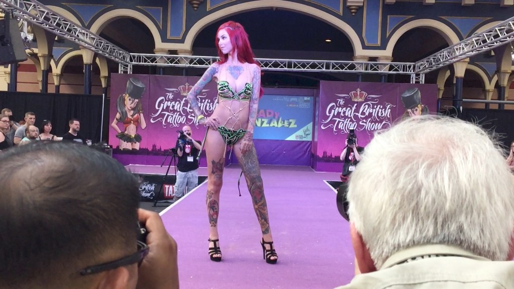 Red-haired tattooed lady modelling lingerie on the catwalk stage.
