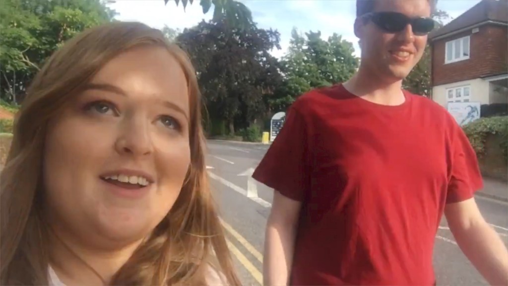Emily and Glen smiling while walking along a street.