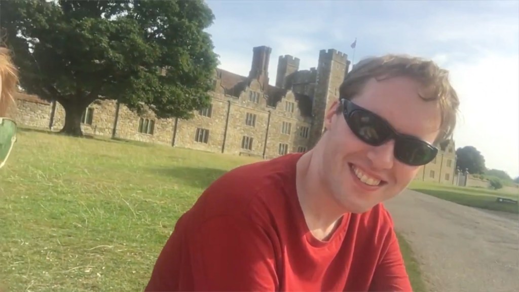 Glen sitting in the sunshine with the large Knole House in the background.