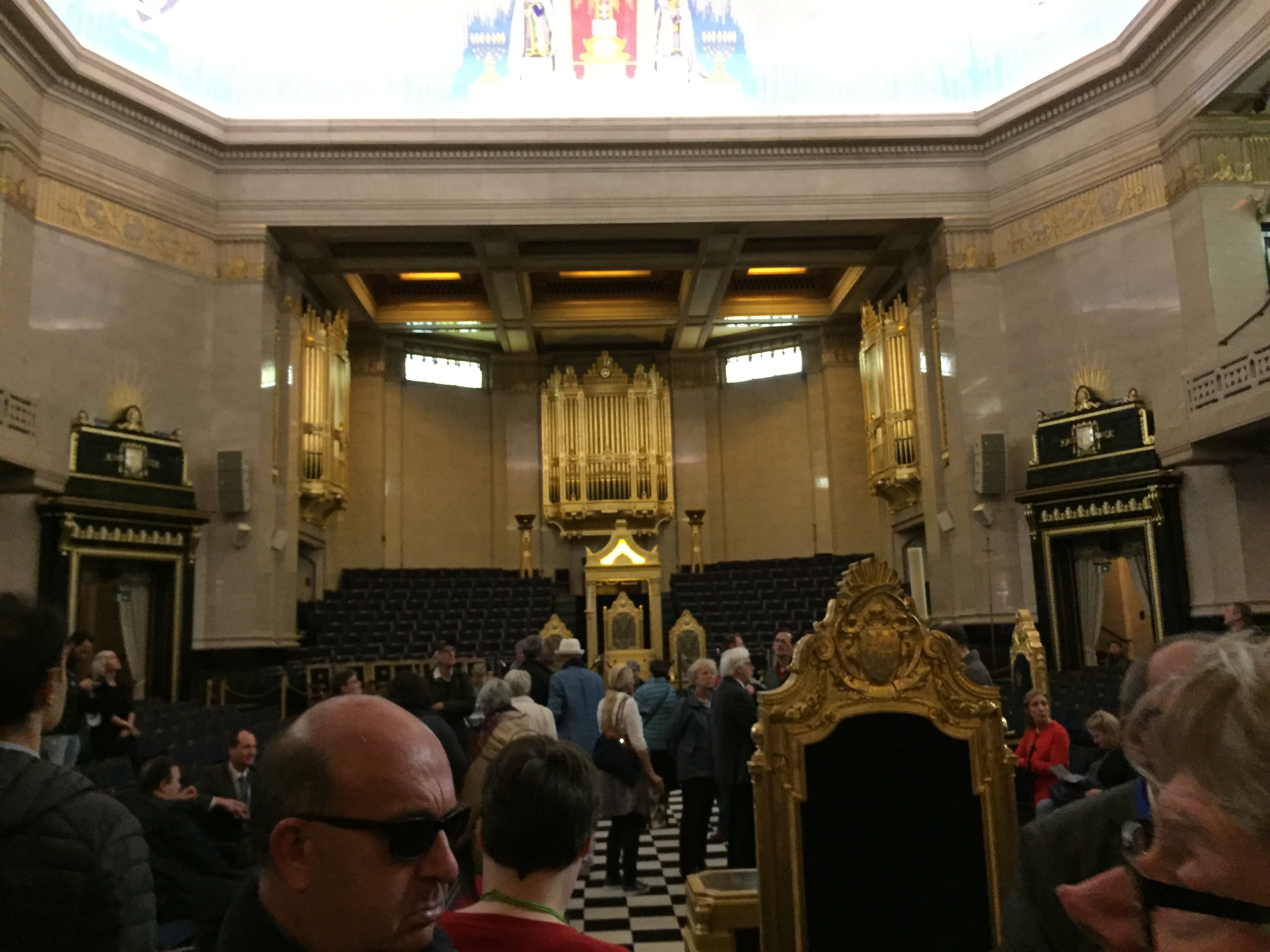 The large ornate temple room in Freemasons' Hall, with a checkerboard carpet floor leading to a large throne, behind which is a huge pipe organ.