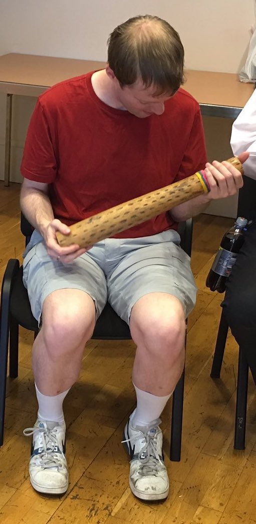 Photo of me holding a long tubular instrument called a Rainmaker