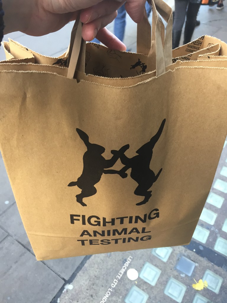 Large brown bag, with a silhouette of 2 rabbits on their hind legs as they face each other, grasping each other's arms, above the words Fighting Animal Testing.