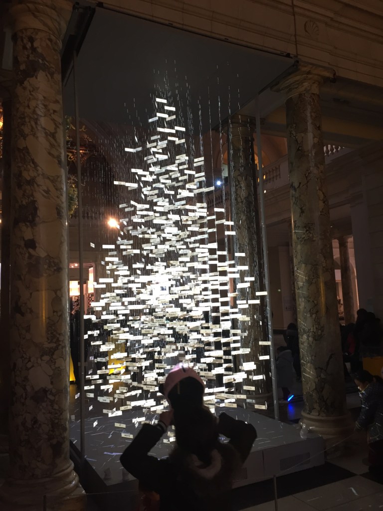 A Christmas tree formed from hundreds of small white rectangular panels, which appear to be floating because of the gaps between them.