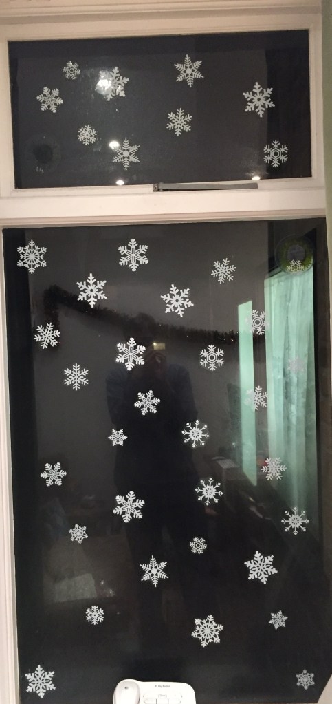 Varied white snowflake patterns stuck all over the lounge window