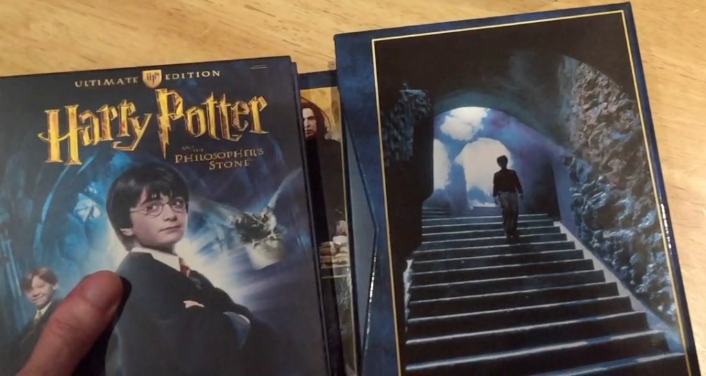 Inside of the Harry Potter Ultimate Edition box set, featuring pictures of Harry posing and walking down some stairs.