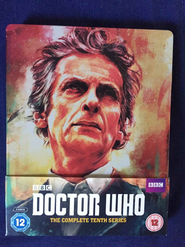 Blu-Ray case for Doctor Who - The Complete 10th series, showing a large portrait of Peter Capaldi's head and shoulders as the Doctor, in front of what appears to be a large explosion.