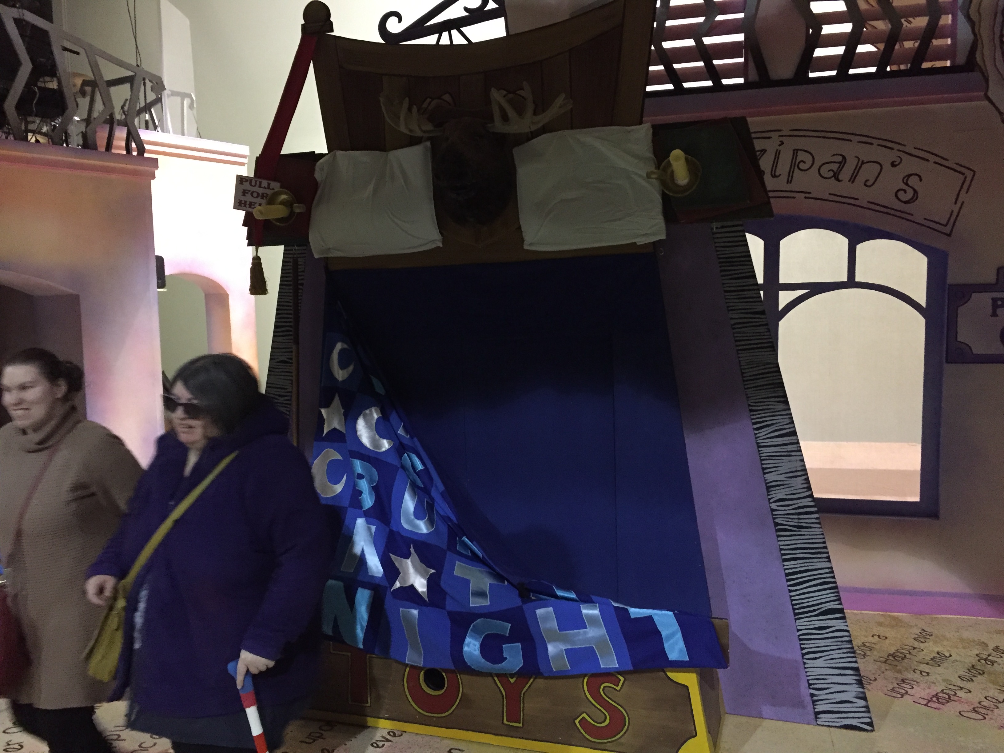 A bed with navy coloured sheets and 2 white pillows, and in between the pillows is a moose's head. The bed is positioned vertically, so the actors stand beneath the sheets, and the audience gets the impression we're looking down on them laying there.