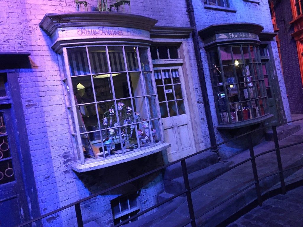 Florean Fortescue's Ice Cream Parlour in Diagon Alley, with ice cream cones visible in the window. The shop Flourish and Blotts is next door.