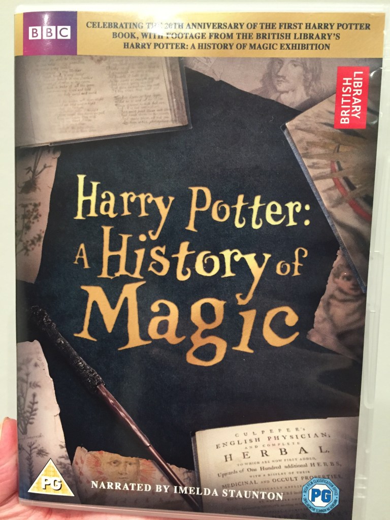 DVD cover for Harry Potter - A History Of Magic. The title is in gold lettering on a black background in the centre, surrounded by old papers and books and a magic wand.