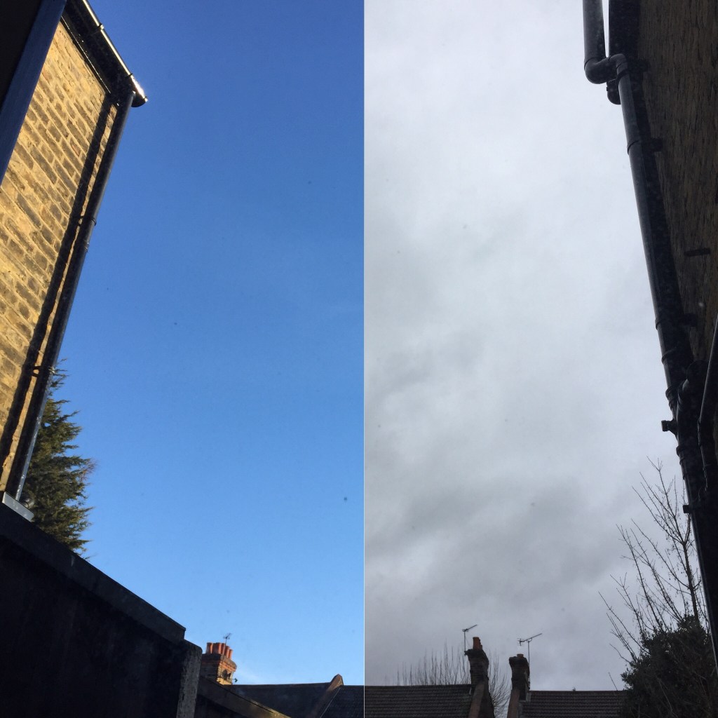 Combination of 2 photos side by side, showing the view up towards the sky from my back window downstairs, with the roofs of other houses just visible at the bottom. The left photo shows a clear blue sky, while the right shows a grey, cloudy sky. The photos are aligned to look like one shot of the view, with the sky changing halfway across.