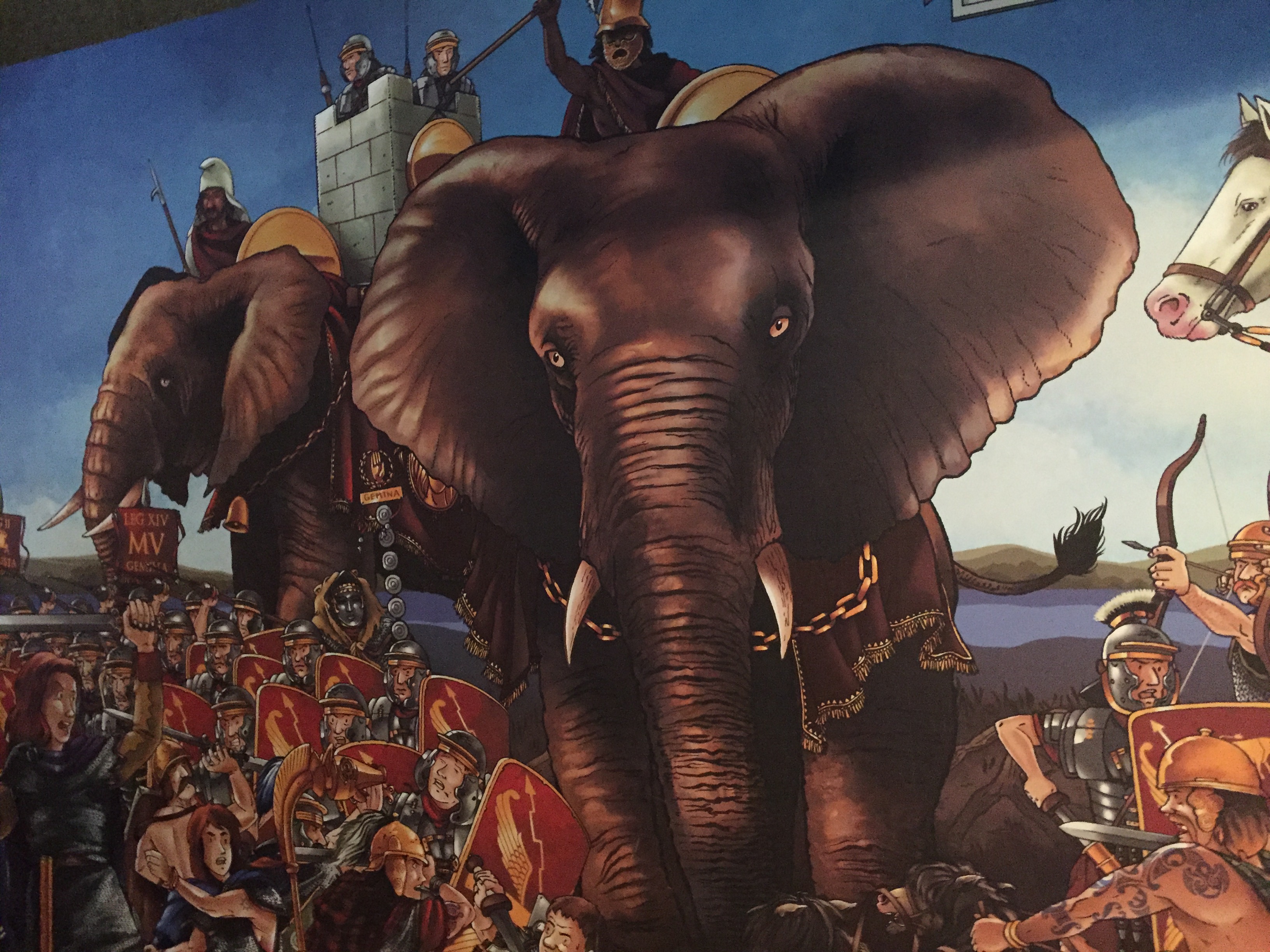 Painting of a Roman soldier riding a huge elephant, surrounded by other Roman soldiers on foot.