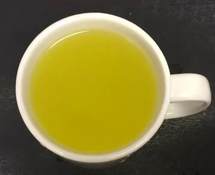 Orange squash in a white mug, viewed from above.