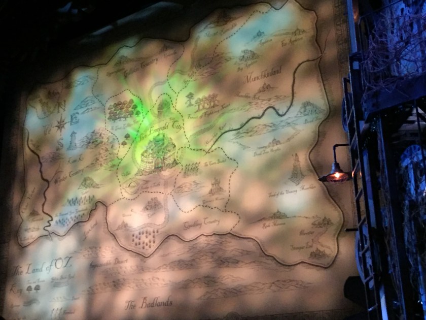 Map of The Land Of Oz on the stage curtain, with The Emerald City in the centre, Gillikin Country to the north, Munchkinland to the east, Quadling Country to the south, and Winkie Country to the west, along with Impassable Desert and Badlands across the southermost section of the map.