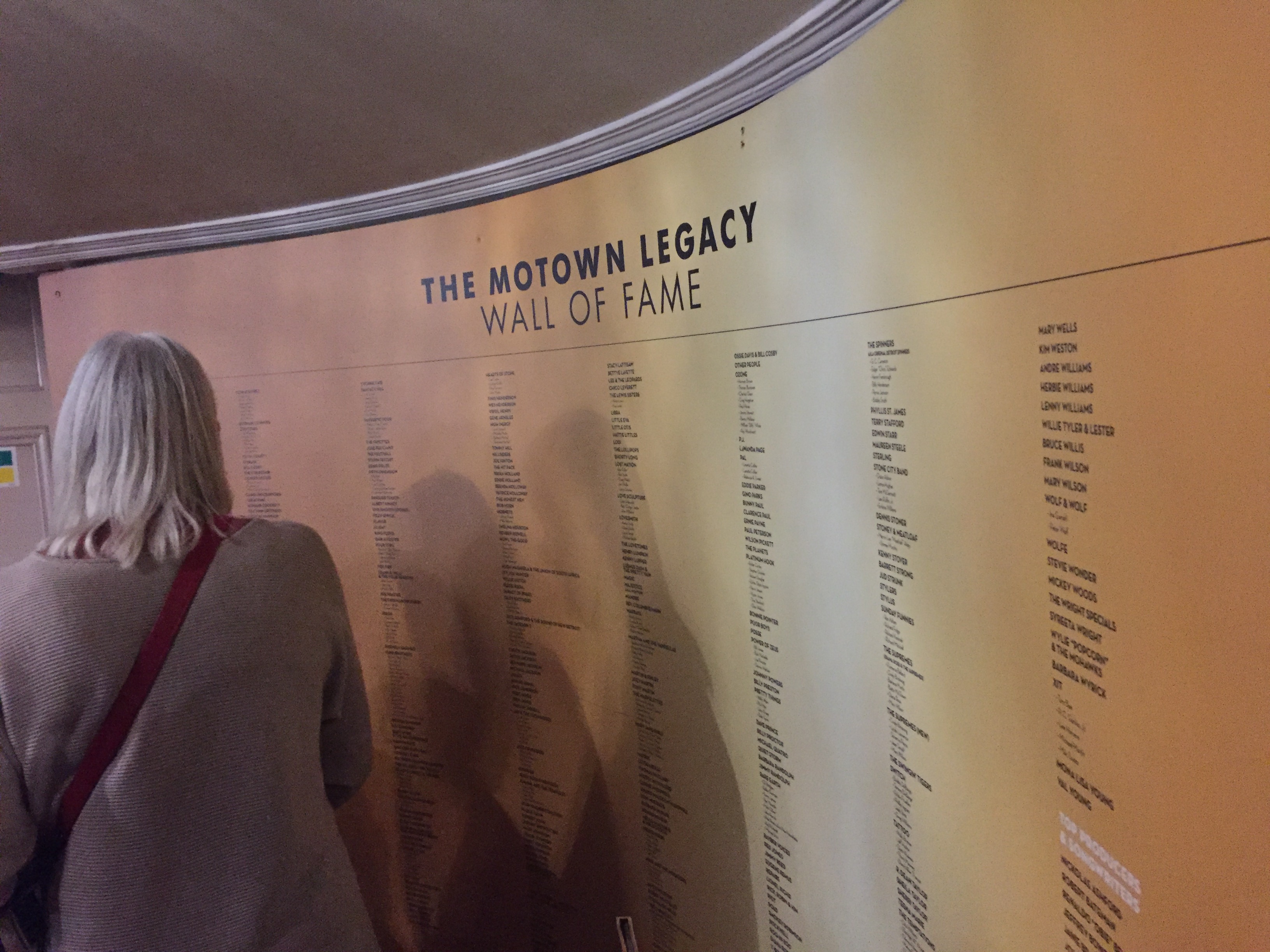 The Motown Legacy Wall Of Fame, a huge gold coloured poster along a curved wall, listing hundreds of names of Motown artists.