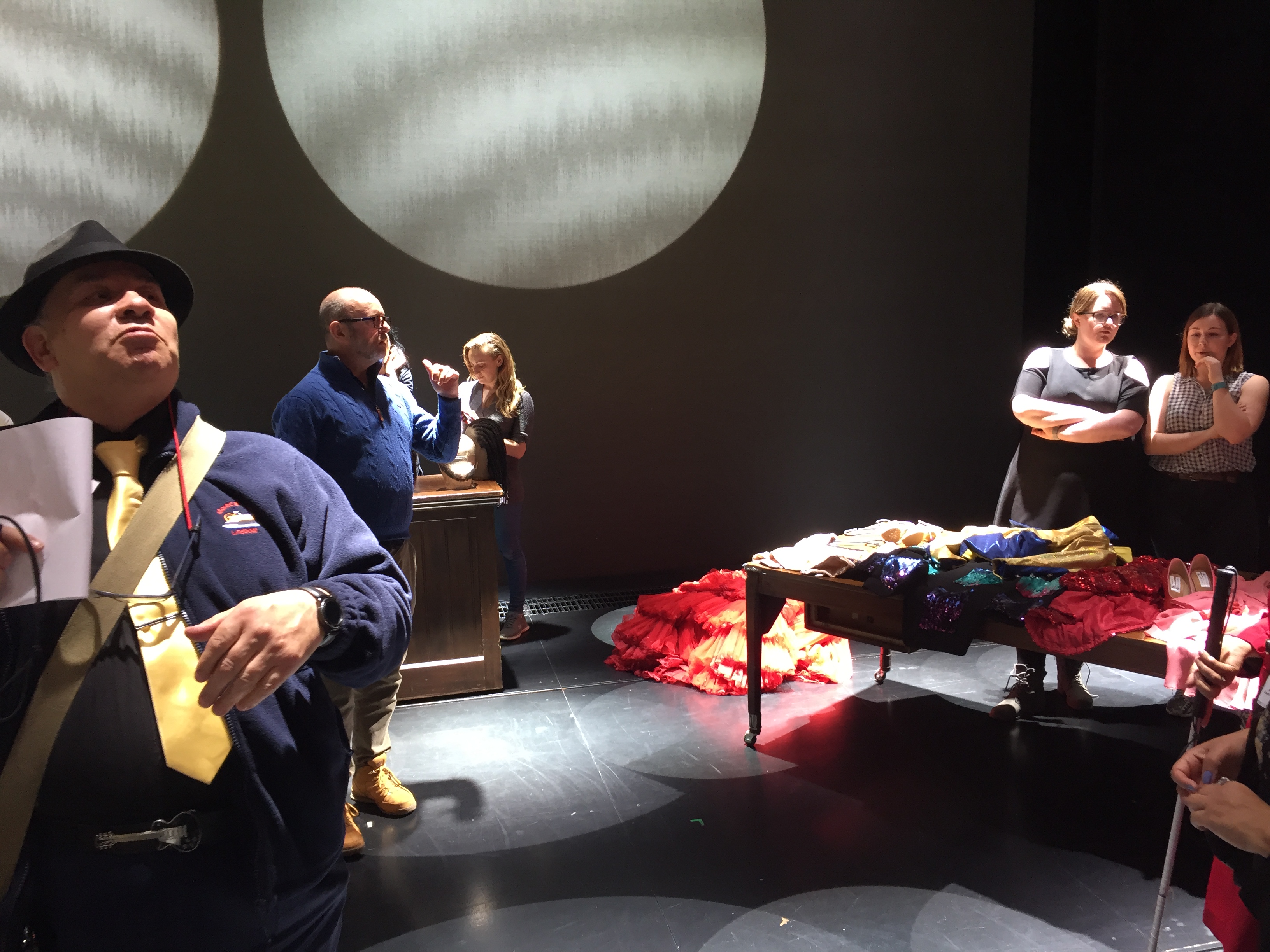 On stage for the touch tour, looking at wigs and sparkling, colourful costumes.