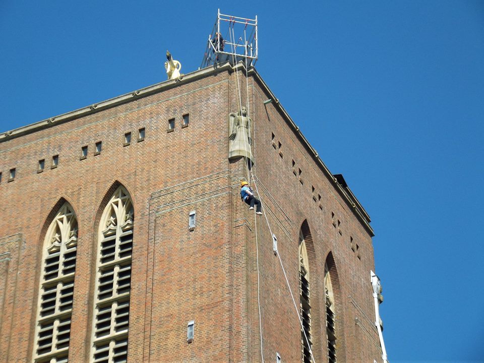 My friends abseiling off the tower of Guildford Cathedral. The line is coming out diagonally from the corner of the tower to the ground, so she's in mid-air, not touching the building.