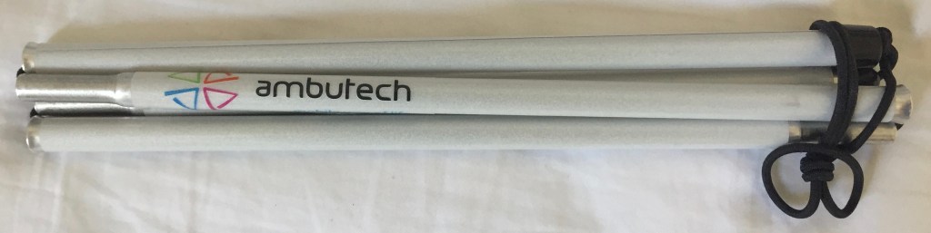 Folded-up white symbol cane, tied with a black elastic cord at one end. One section of the cane has the company name Ambutech on it.