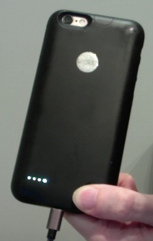 Rear of black iPhone case. Pressing a button on the bottom right reveals 4 small lights in a row on the left, to show the case is fully charged. Below this, the charging cable is plugged into the bottom of the case, in the same central position as the iPhone charging port is located inside the case. At the top of the case, a hole is left open for the camera and flash.