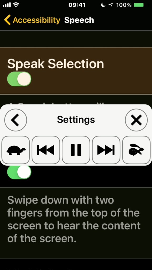 iPhone screenshot of the Speech menu, with Speak Selection and Speak Screen options. A box overlays the centre of the screen as the phone reads the menu text aloud, containing buttons to pause, fast forward and rewind, and slow down or speed up the speech.