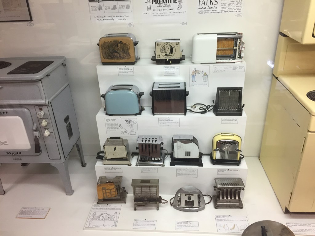 4 shelves containing 14 toasters in a variety of different designs.