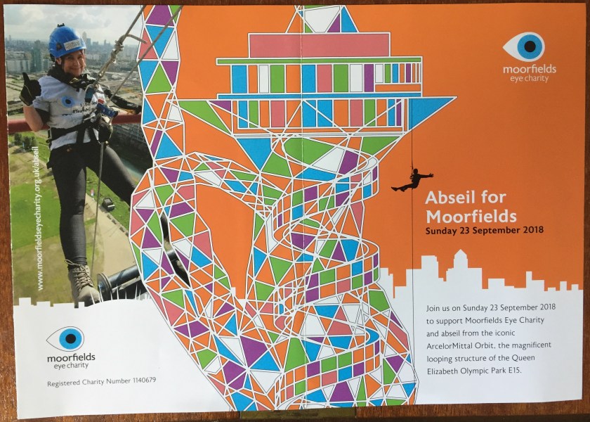Leaflet called Abseil For Moorfields. Central image shows a multi-coloured illustration of the Orbit Tower, a tall structure with lots of curves and a helter skelter slide running down the outside. To its left is a photo of a lady waving as she prepares to do her abseil. To the right is text inviting people to join in the abseil on Sunday 23rd September 2018.