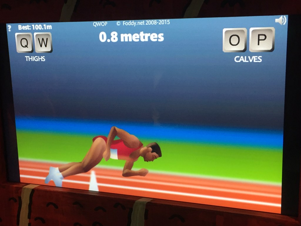 The computer game QWOP. The athlete on the screen, wearing a red top and shorts, is falling face first on to the running track, just over the start line. Text at the top says the distance covered is just 0.8 metres.