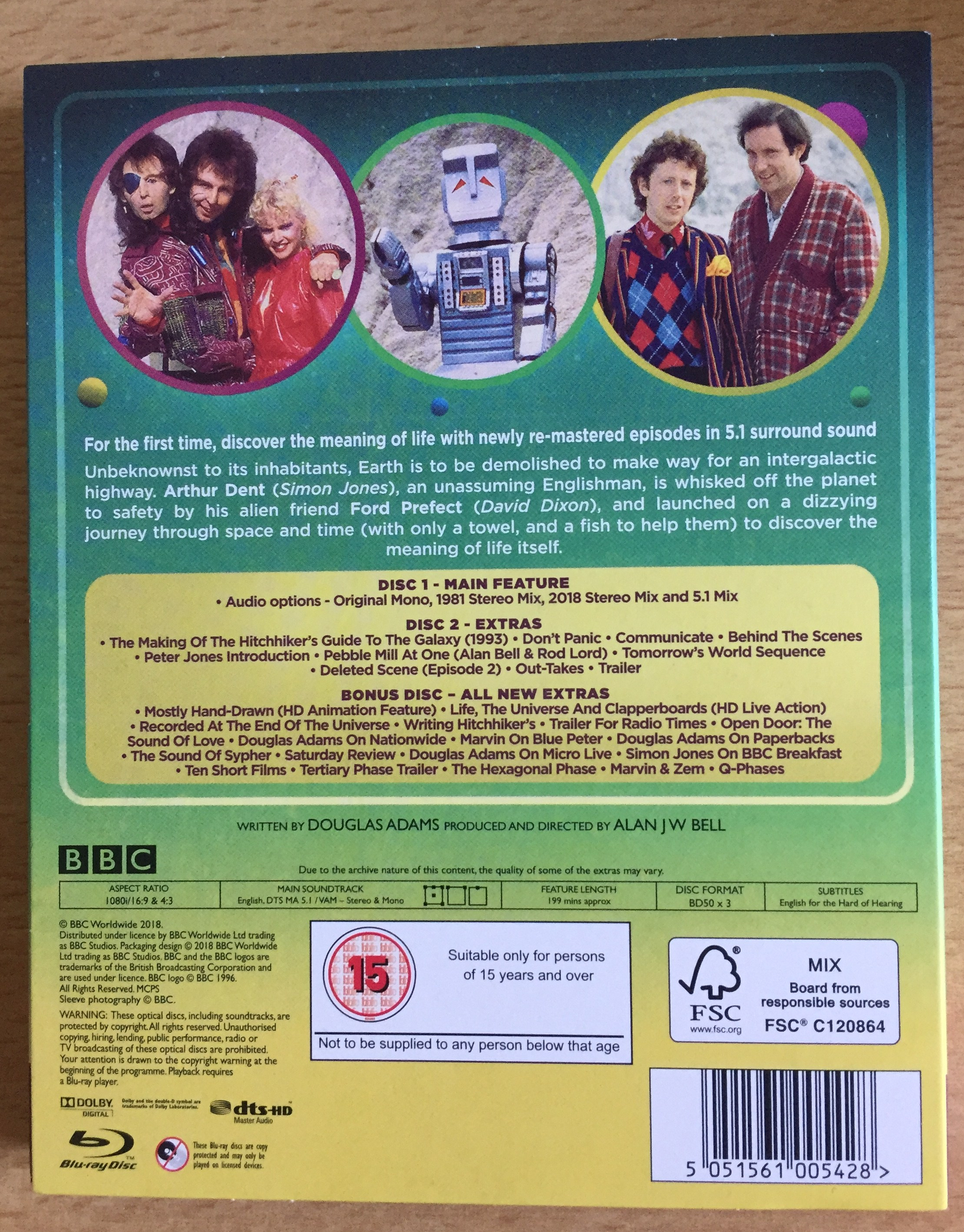 Back cover of The Hitchhiker's Guide To The Galaxy Special Edition Blu-ray, with a synopsis of the story and photos of the main characters. Audio options include the original mono mix, stereo mixes and a surround sound mix. Special features include many behind the scenes details about the series and interviews with Douglas Adams, plus a deleted scene, outtakes and a trailer.