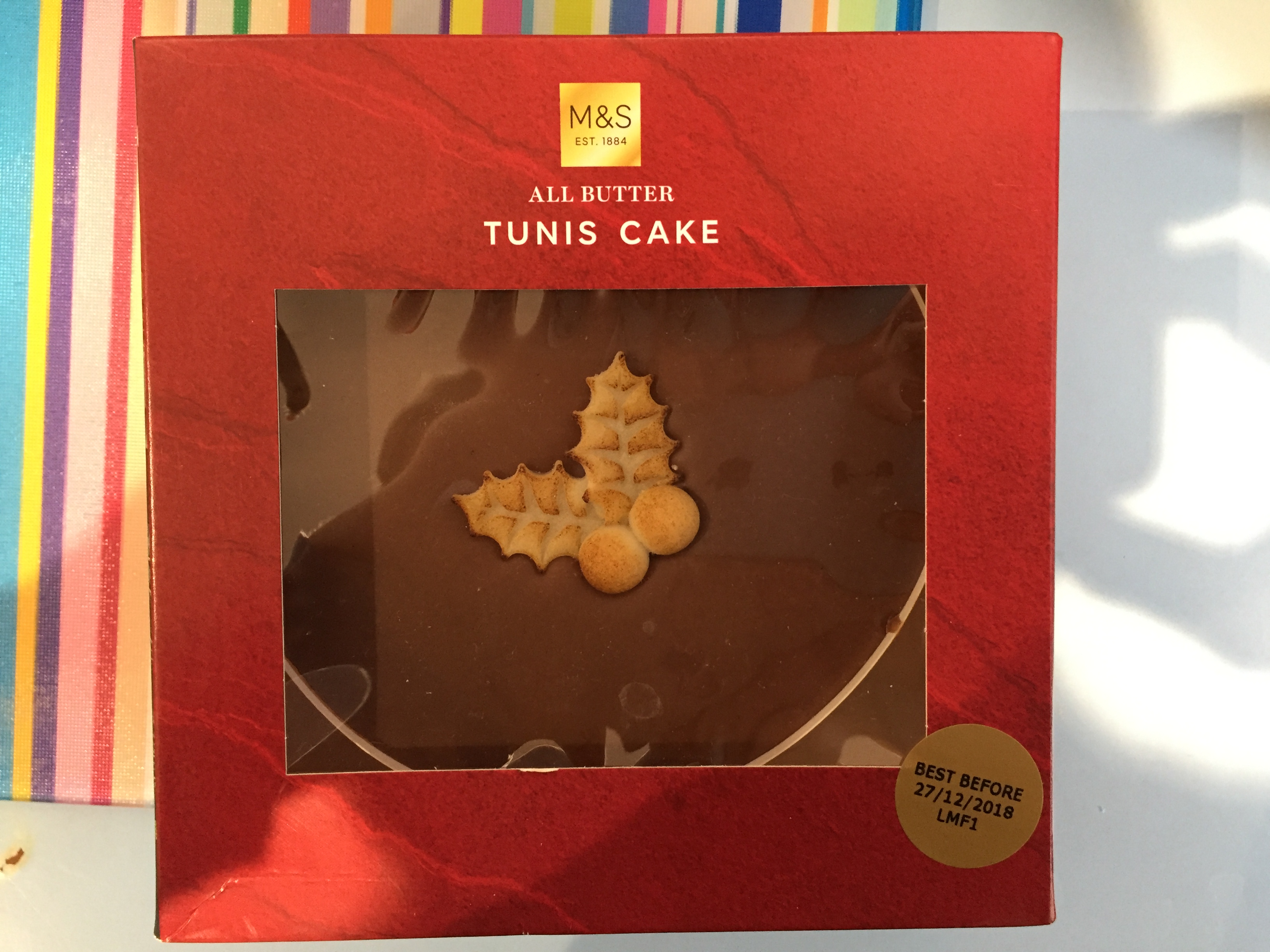 Marks & Spencer Tunis Cake, an all butter sponge cake with chocolate on the top, with small marzipan fruits and leaves in the centre of the chocolate.