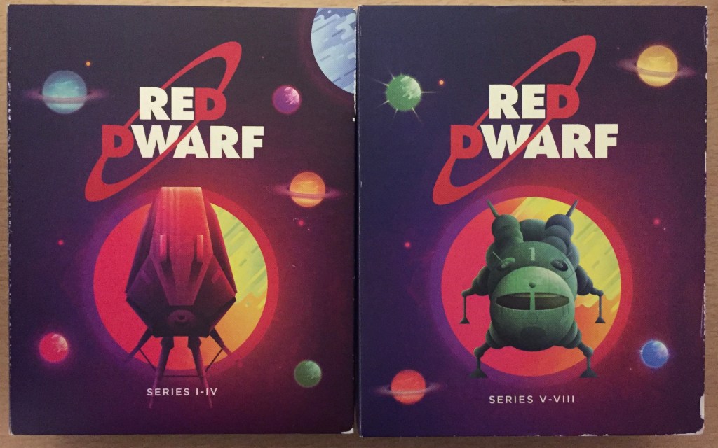 The front covers of the 2 flipbook cases inside the Red Dwarf Series 1 to 8 box set, the left case for series 1 to 4 and the right case for series 5 to 8. In each case, below the Red Dwarf logo, a ship flies towards us from a large orange planet or sun. The series 1 to 4 case shows Red Dwarf, while the series 5 to 8 case shows the smaller green Starbug ship.