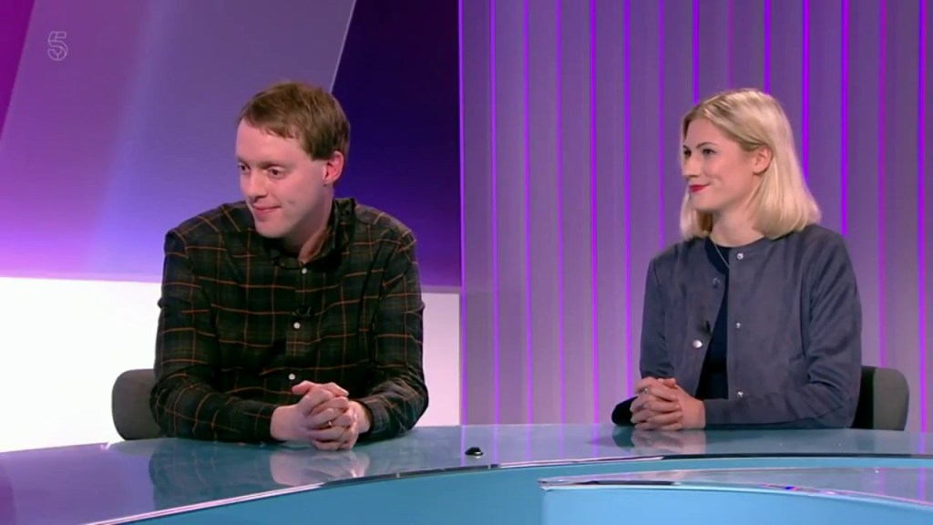 Glen and Krissie sitting next to each other at a glass desk in the Channel 5 News studio, with a purple backdrop behind them.