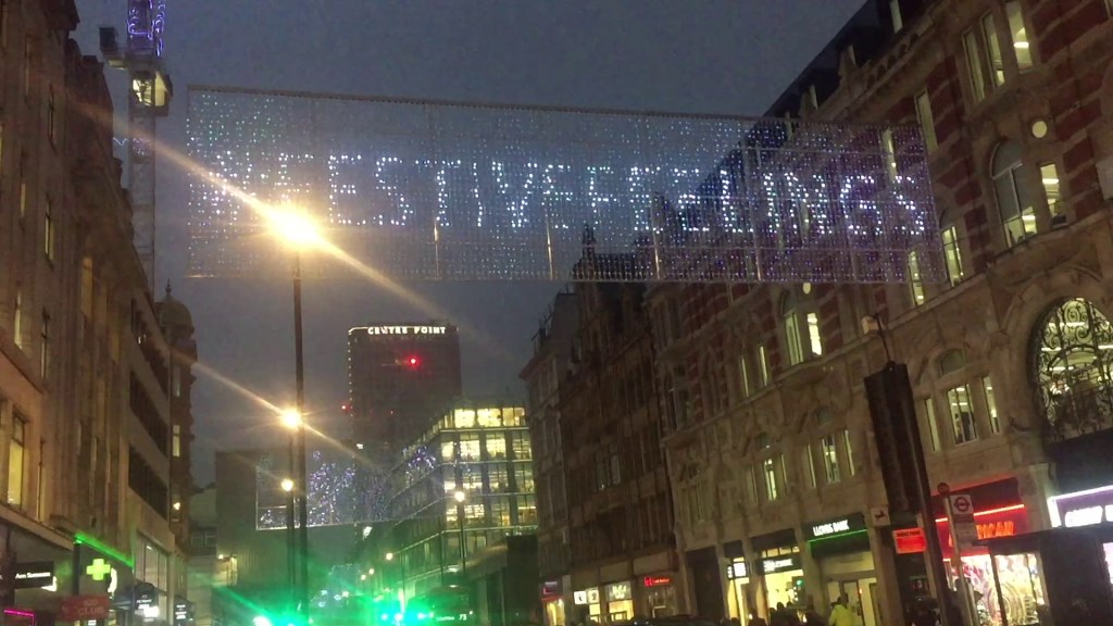 A rectangular strip of lights stretched across Oxford Street, that can be lit up in any combination to form images and messages. Here the lights are displaying the hashtag Festive Feelings.