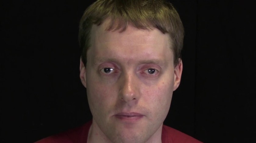 Headshot of Glen against a black background, looking straight at the camera