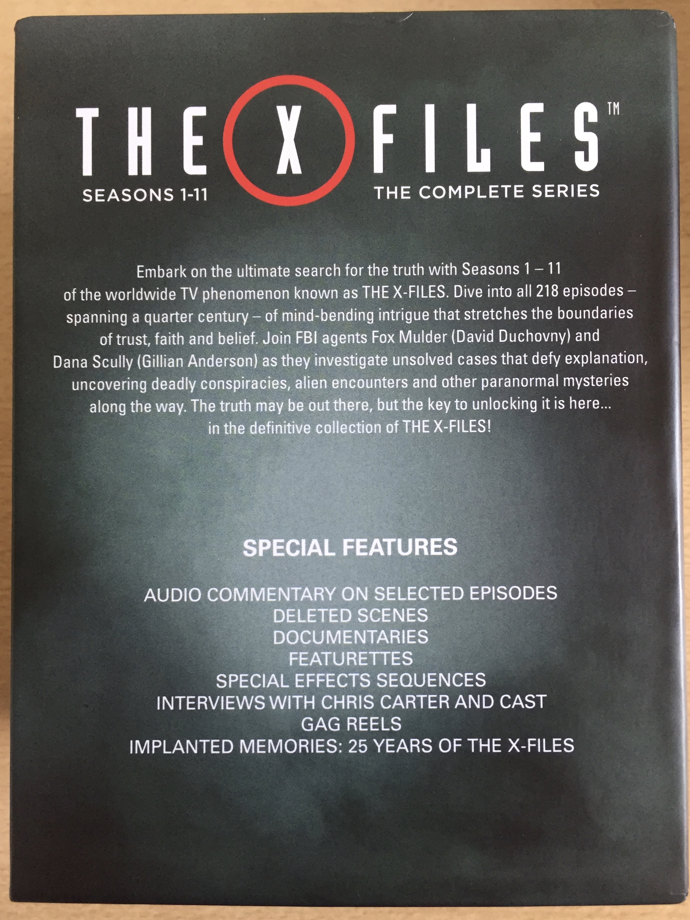 Back cover of the Blu Ray Box Set for The X Files, with a brief synopsis of the show, and a list of special features, including audio commentaries, deleted scenes, documentaries, special effects, interviews with Chris Carter and cast, gag reels and more.