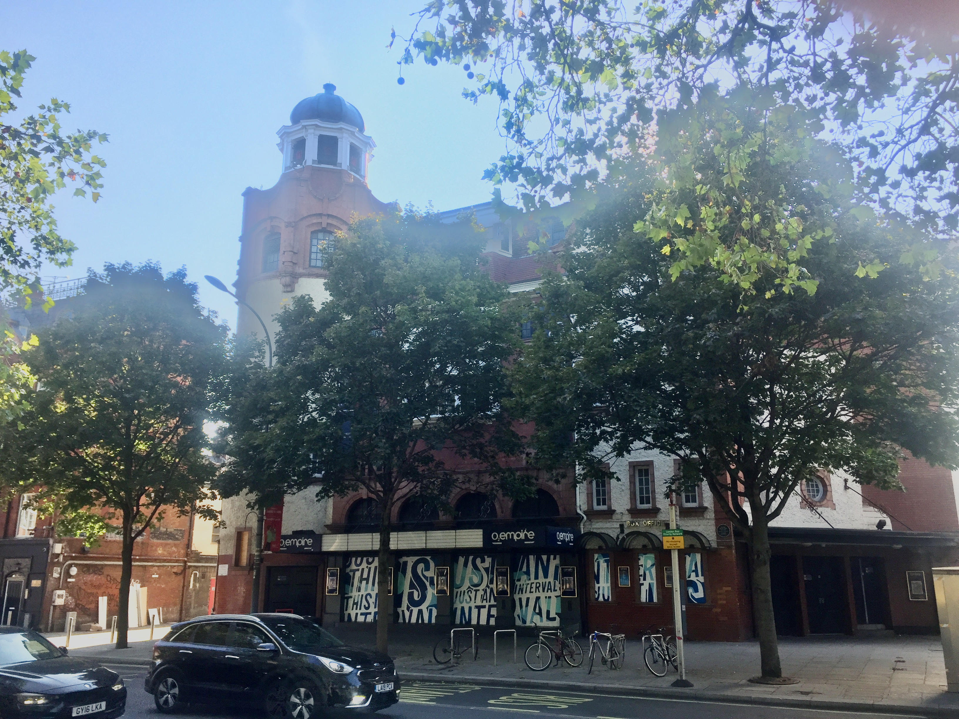 The Shepherd's Bush Empire, a red brick building with at least 4 floors, plus a circular domed tower on the front left corner.