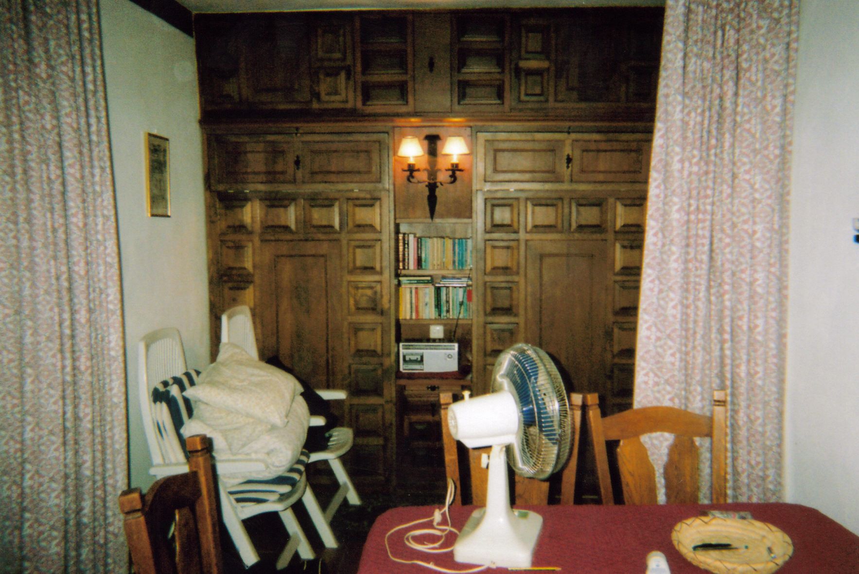 Another view of the lounge in my Spanish apartment, looking towards a wood panelled wall, which actually consists of a pull-down bed on either side of the lights, bookshelves and radio in the centre.