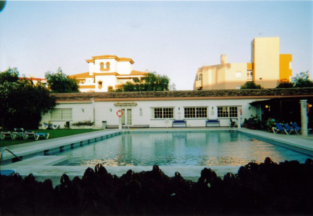 Swimming pool at Carihuela Park Palace, with a few sun loungers available nearby.
