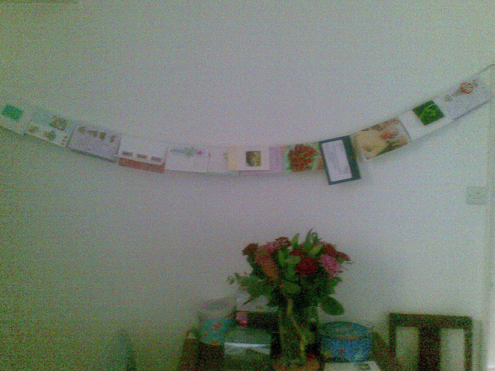 Several cards for my Nan's 100th birthday, hung up on a long line of string on the wall.