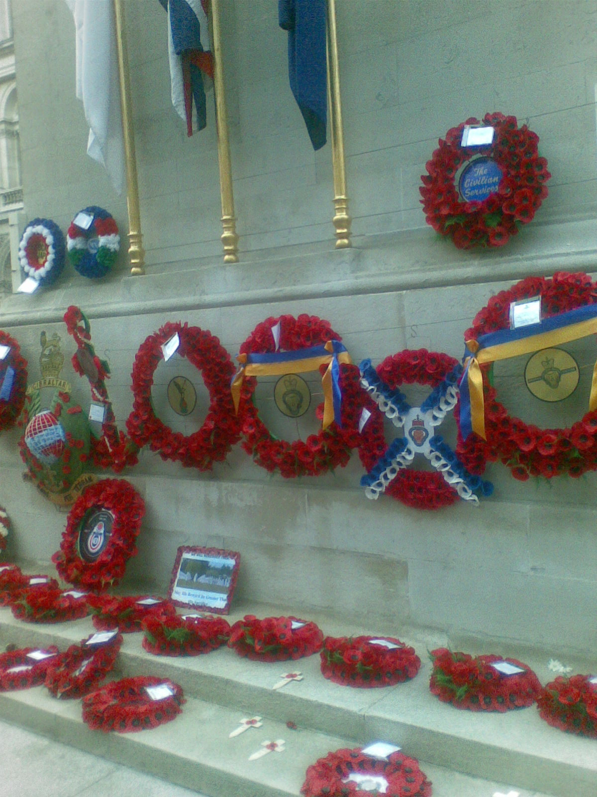 Poppy wreaths at the base of the Cenotaph monument, some adorned with colourful ribbons