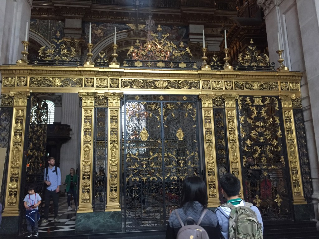 Large black and gold gate with a very ornate design inside St Paul's Cathedral