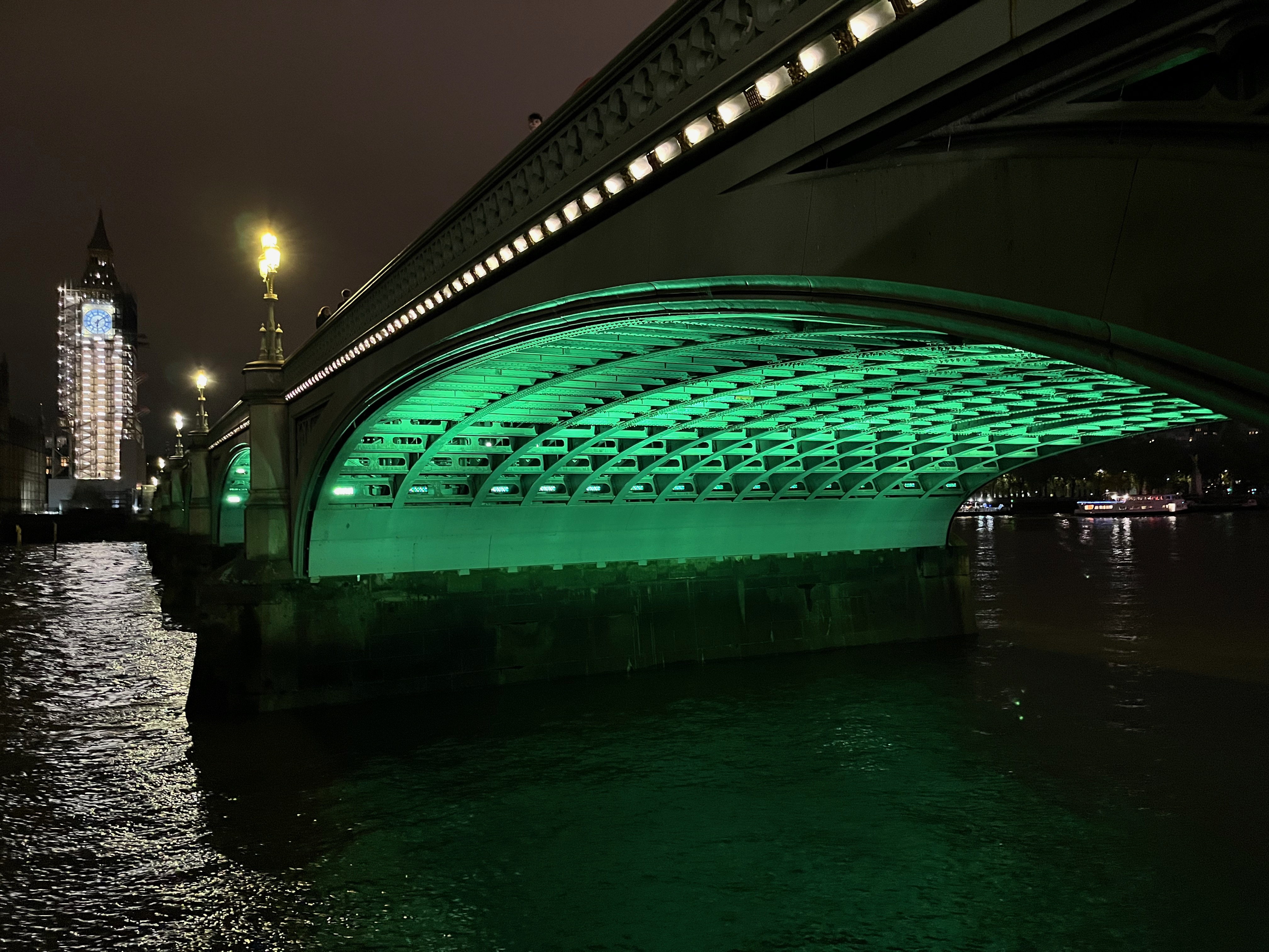 Close-up of the green lighting underneath one of the arches of Westminster Bridge.
