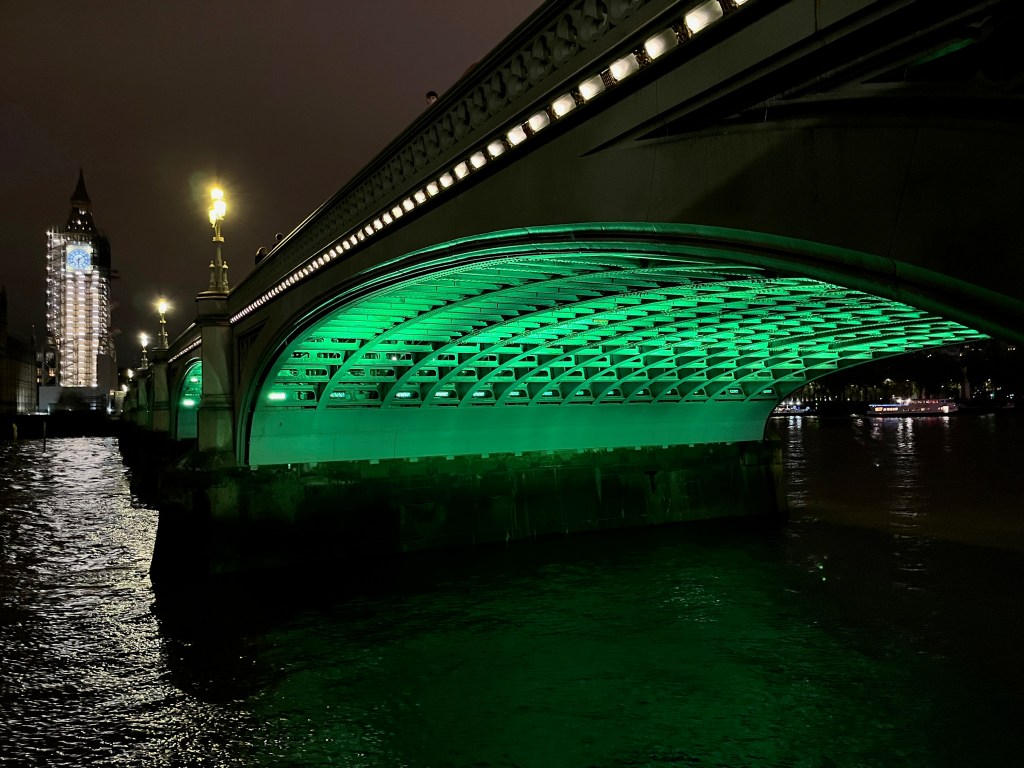 Close-up of the green lighting underneath one of the arches of Westminster Bridge.