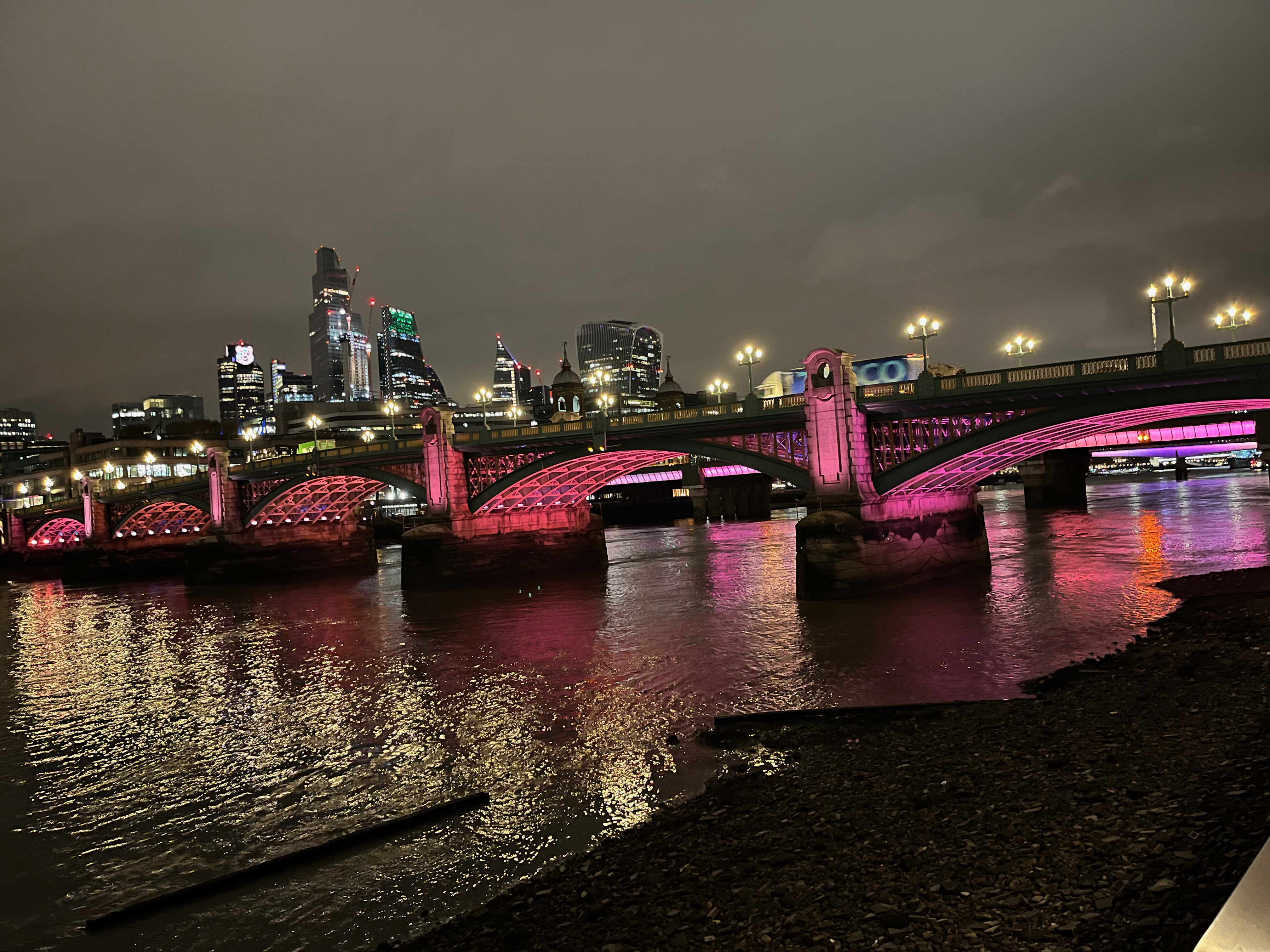 Southwark Bridge, with pink and red lighting beneath its 5 arches.