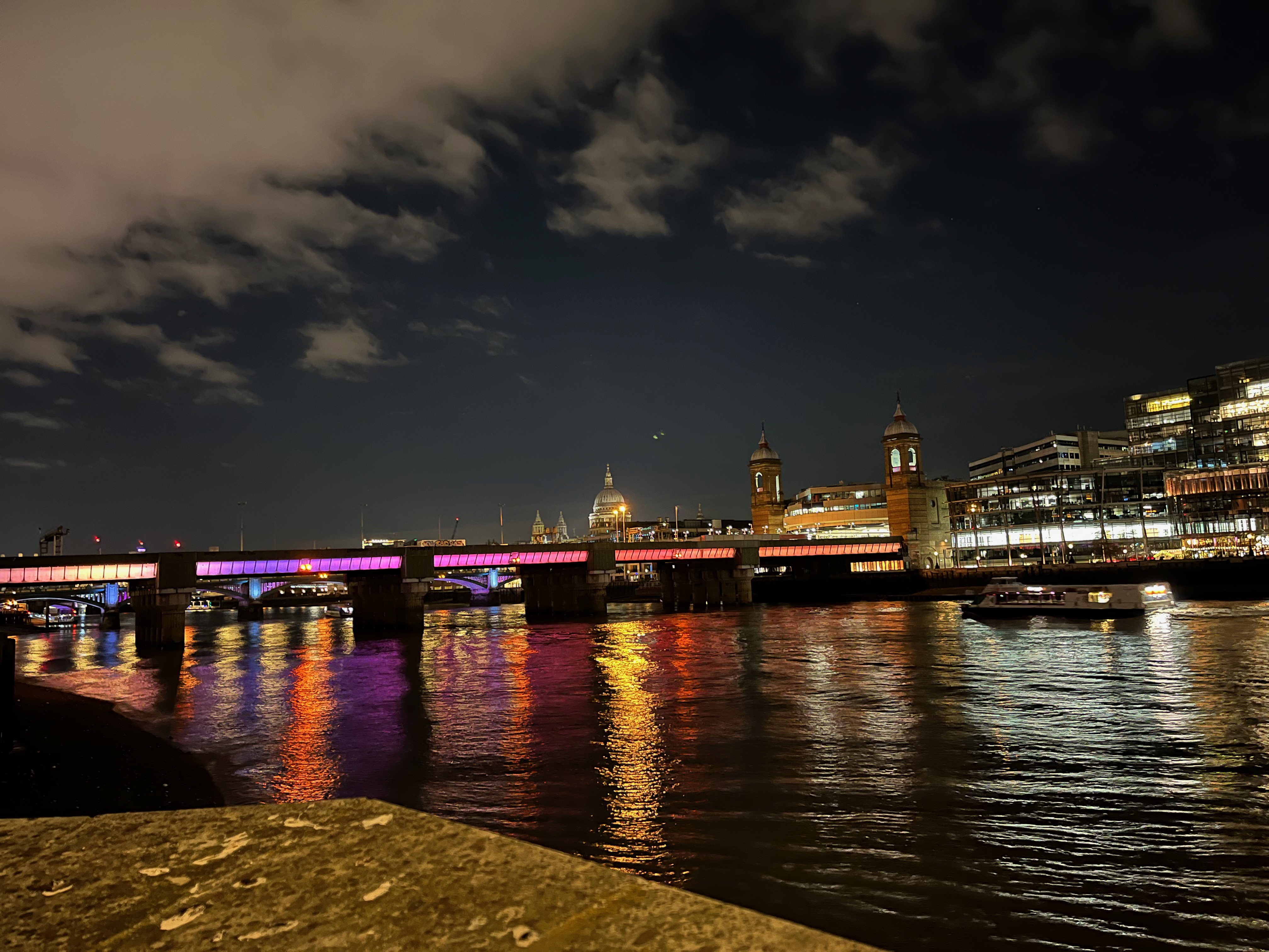 Cannon Street Railway Bridge, with each of the 5 sections having a thick band of yellow, purple or red light along the side.