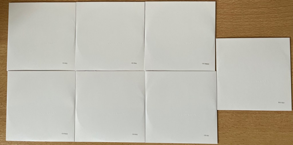 Front covers of the disc sleeves from the White Album box set. Each is white in colour, with small embossed white text saying The Beatles, and small black text giving the disc number.