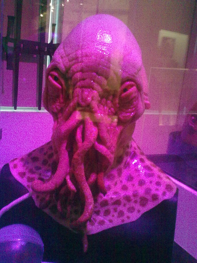 The head of an Ood from Doctor Who, a bald alien creature with tentacles coming out of its nose and mouth.