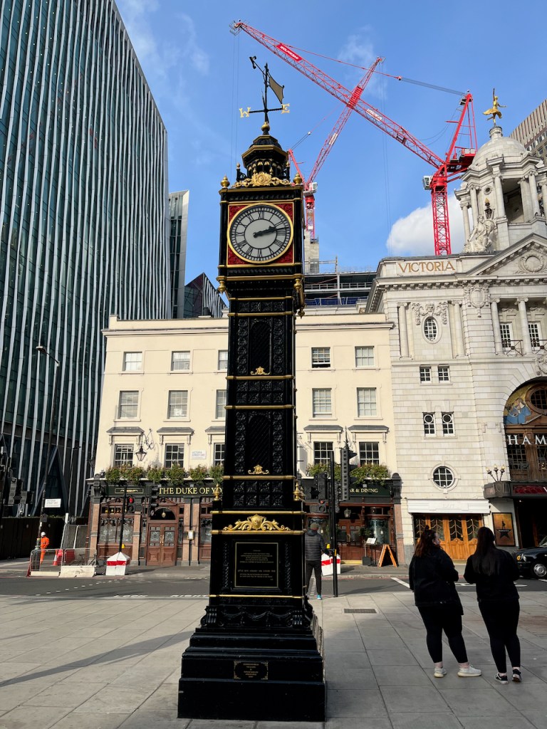 Little Ben, a black clock tower with ornate gold decoration and a weather vane on top.