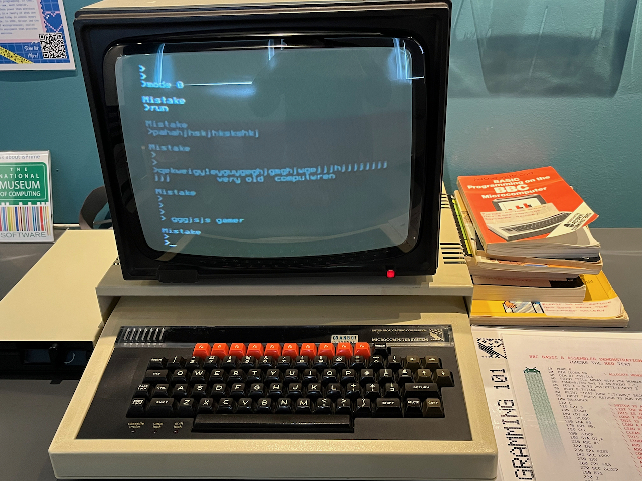 BBC Micro computer, with a black monitor and a black and white keyboard, except for the red function keys across the top of the keyboard.