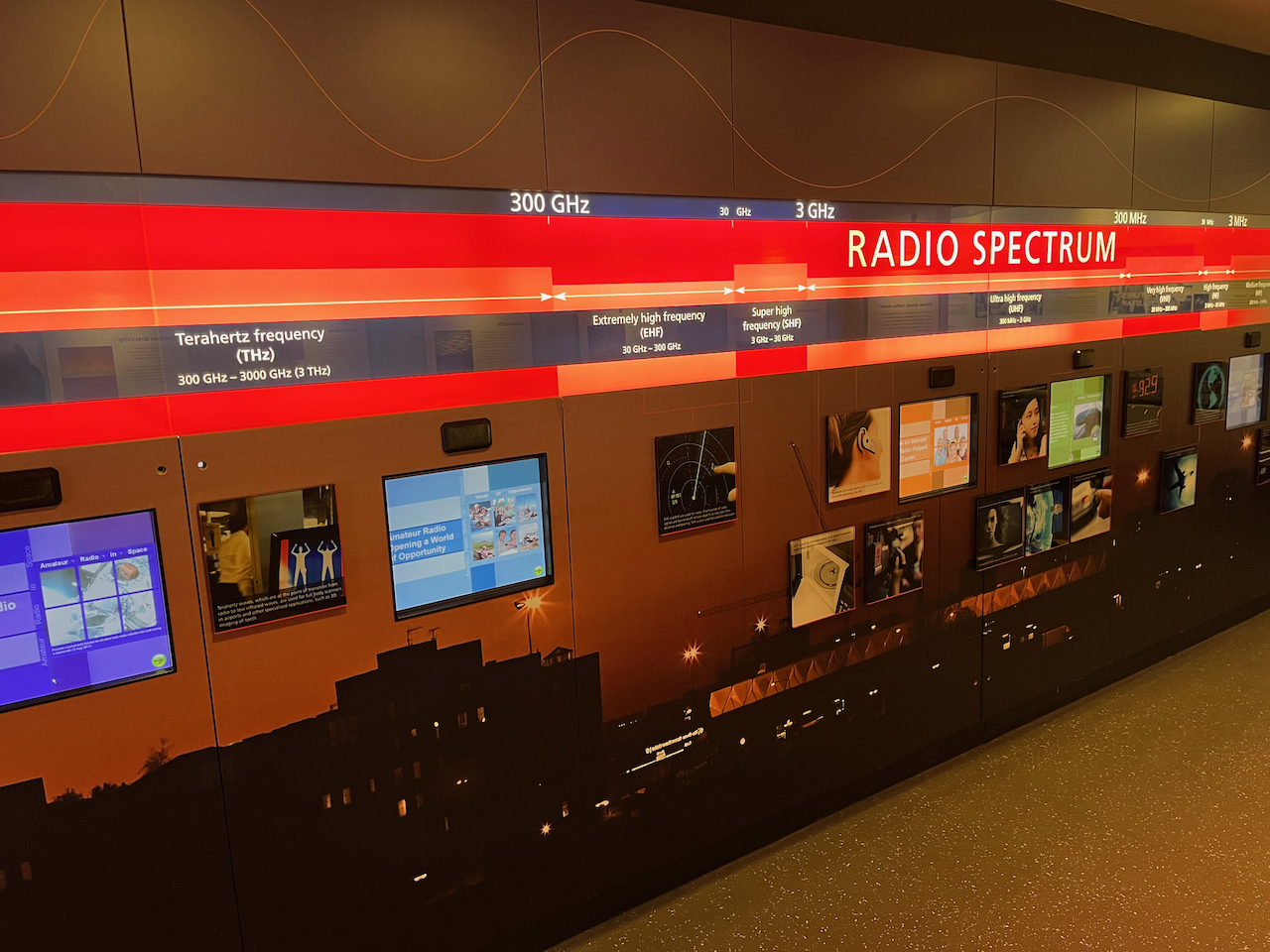 A large wall display showing the different parts of the radio spectrum, including medium, high, very high, ultra high, super high, extremely high, and terahertz frequencies.