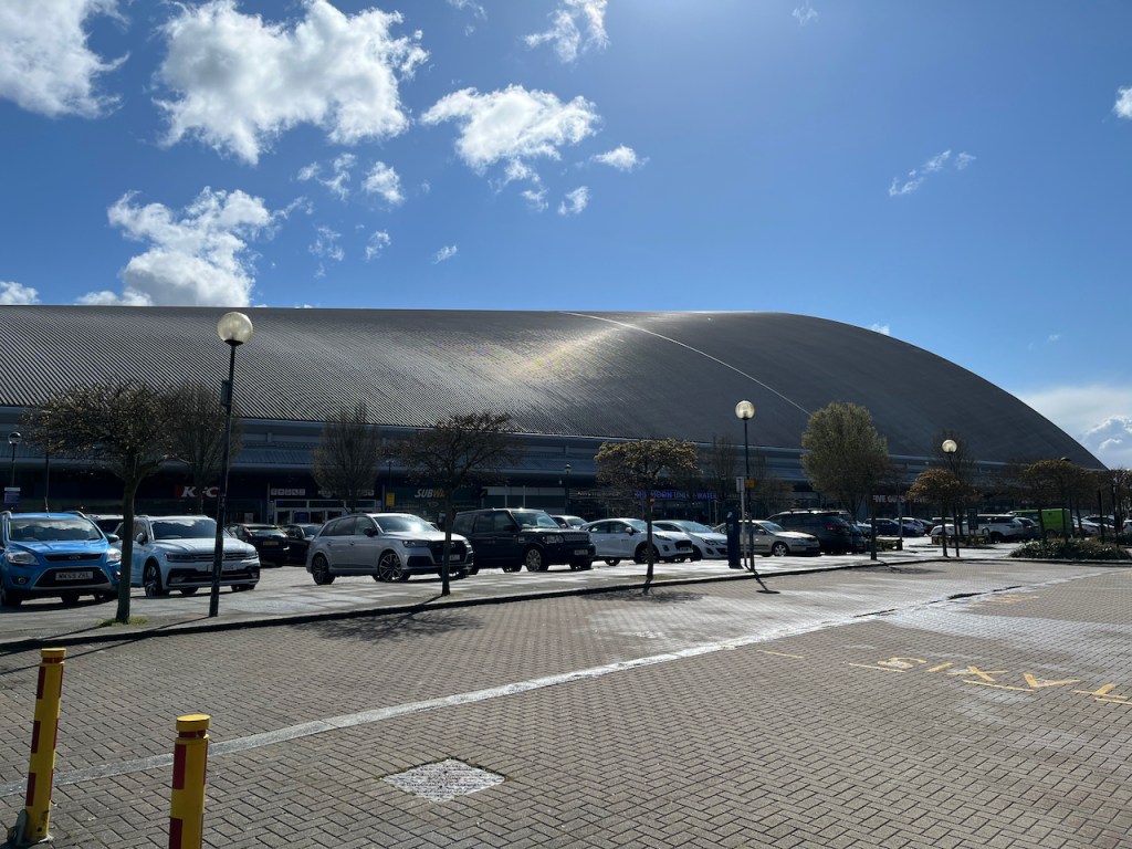 The Xscape centre in Milton Keynes, a large and long building with a bulging, curved roof.
